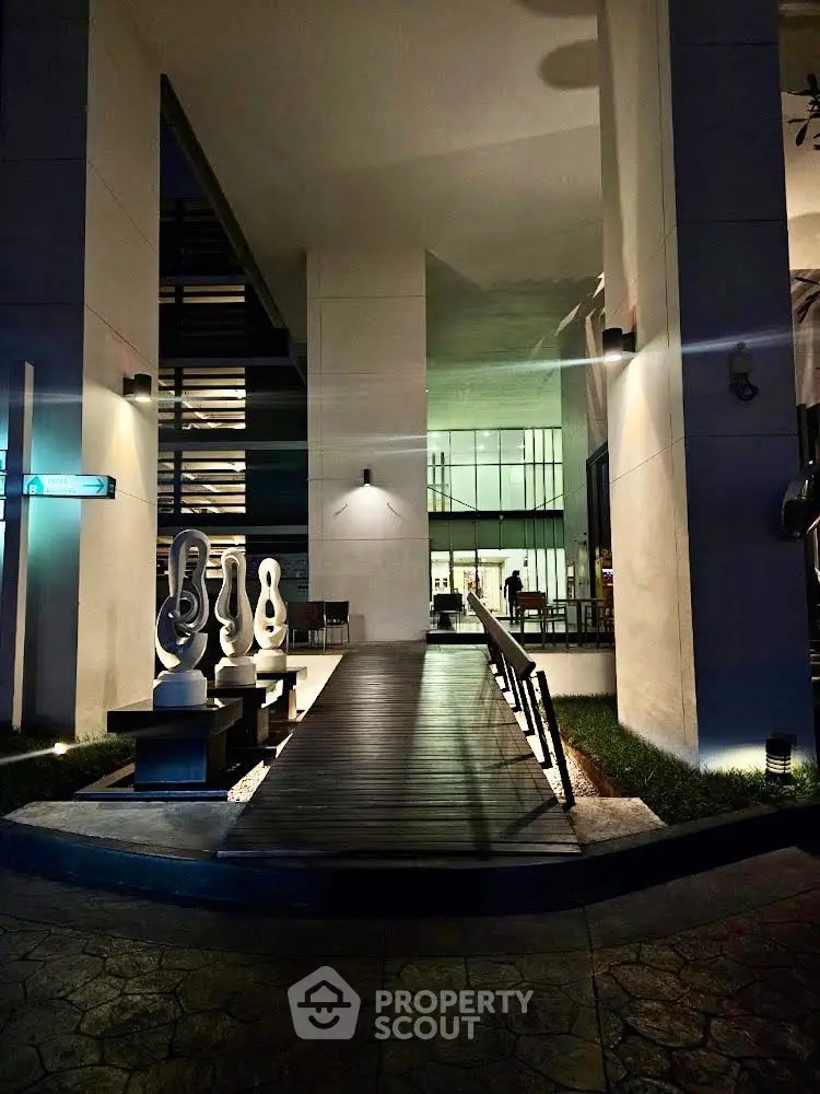 Modern building entrance with artistic sculptures and sleek design