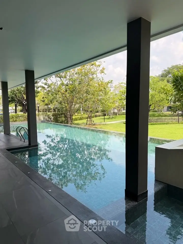 Luxurious infinity pool with serene garden view in modern residential complex.