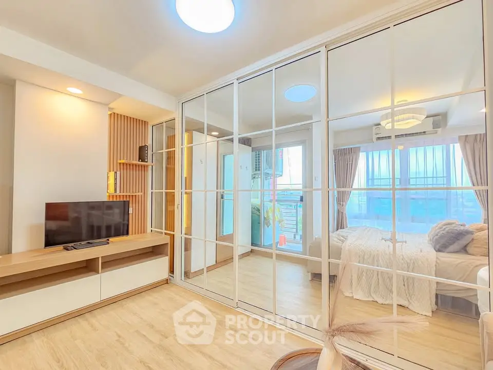 Modern bedroom with mirrored wardrobe and natural light