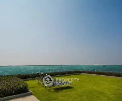 Luxurious oceanfront garden with stunning sea view and lounge chairs, perfect for relaxation.