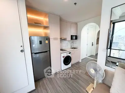 Modern compact kitchen with integrated appliances and cozy living area