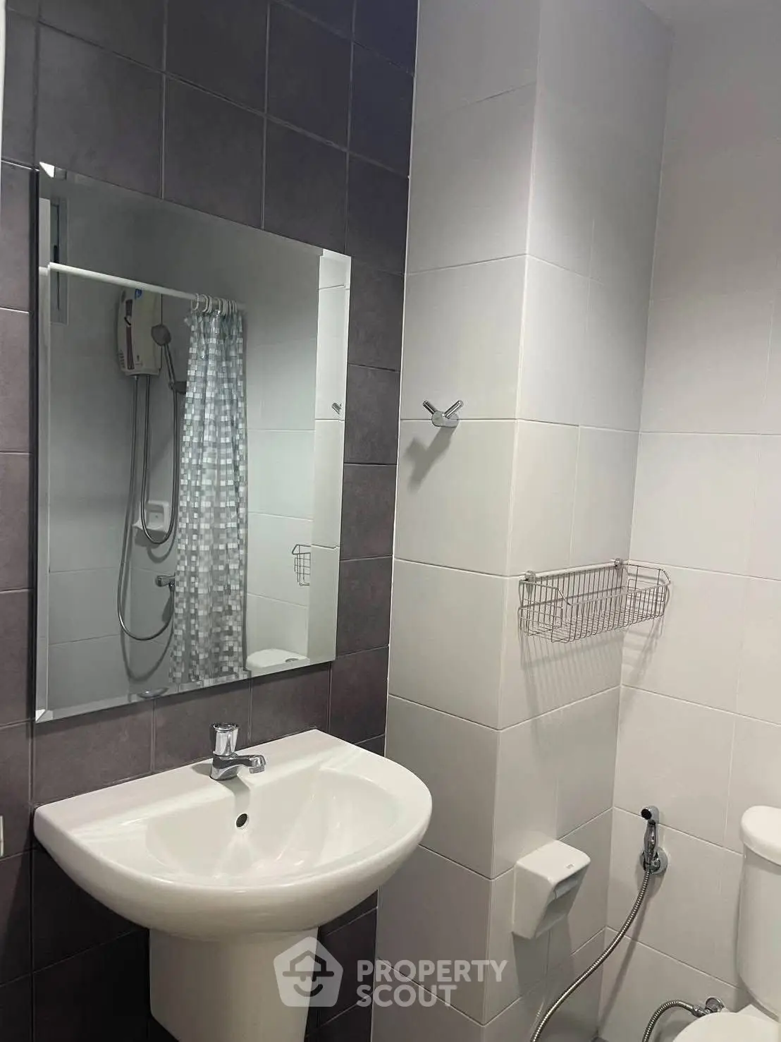 Modern bathroom with sleek sink and shower area, featuring stylish tile design.