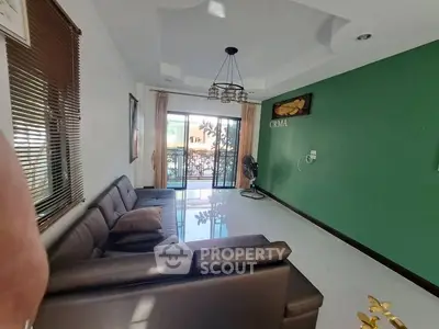 Spacious living room with modern decor and large windows leading to a balcony.