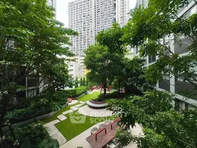 Lush garden courtyard in modern residential complex with tall buildings and vibrant greenery.