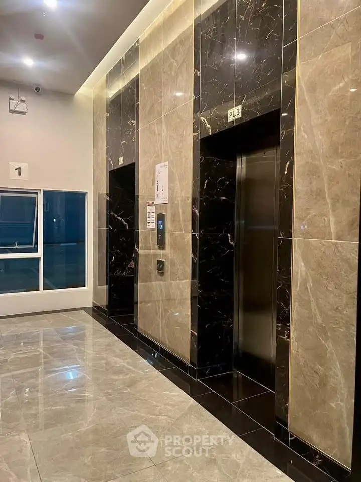 Luxurious marble elevator lobby with modern design and polished floors in a high-end building.