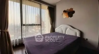 Spacious bedroom with large windows offering stunning city views