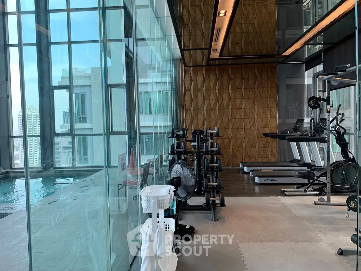 Luxurious gym with modern equipment and pool view in high-rise building