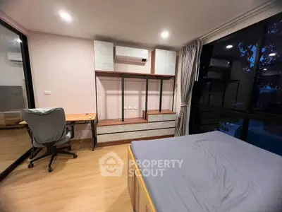 Modern bedroom with desk, chair, and large window offering serene views.