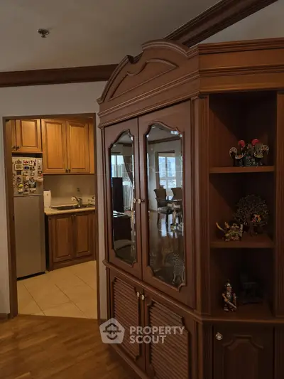 Charming wooden interior with kitchen and living room view, featuring elegant cabinetry and cozy ambiance.