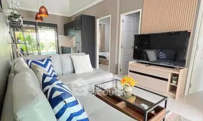 Modern living room with stylish decor and open layout, featuring a cozy sectional sofa and large TV.