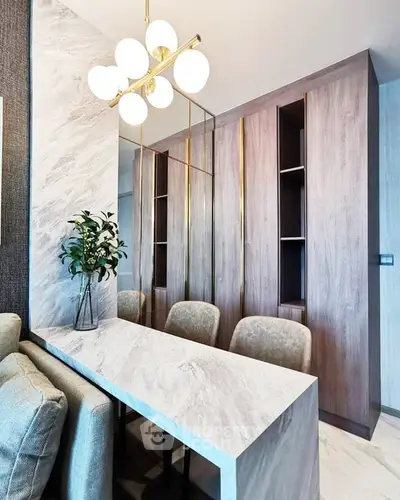 Modern dining area with elegant marble table and stylish lighting in a contemporary apartment.