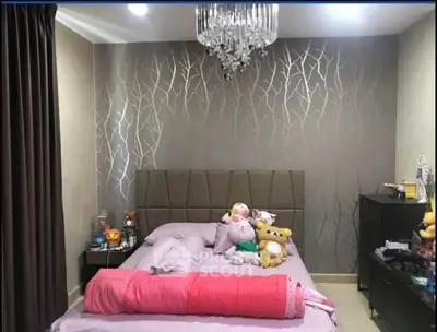 Cozy bedroom with elegant wallpaper and plush toys, featuring a modern chandelier and stylish decor.