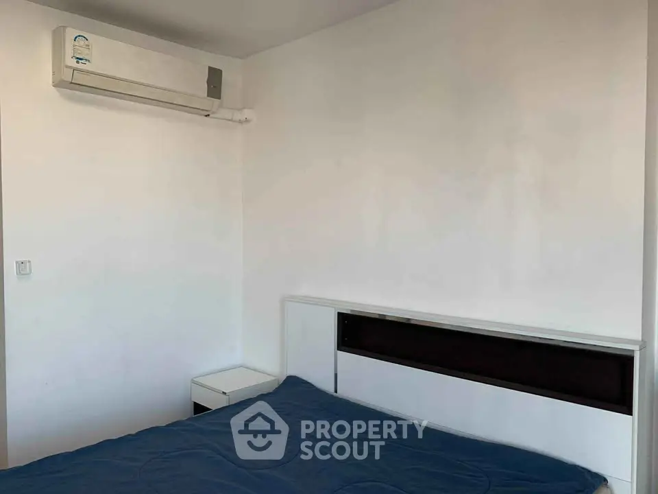 Minimalist bedroom with air conditioning and modern furniture, perfect for a cozy living space.