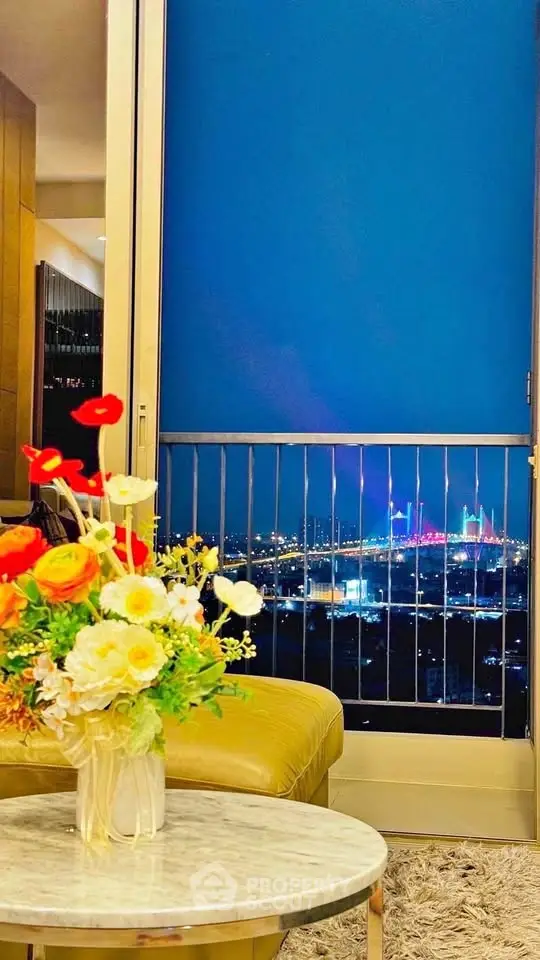 Luxurious living room with stunning night city view and elegant floral arrangement.