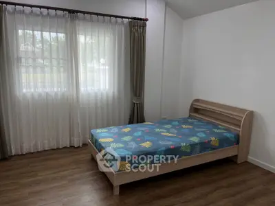 Cozy bedroom with single bed and large window, perfect for natural light lovers.