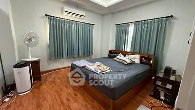 Spacious bedroom with wooden flooring and modern furnishings, featuring air conditioning and natural light.