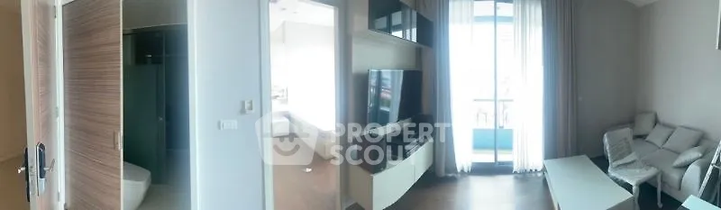 Modern living room with large TV and balcony access in bright apartment.