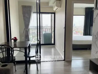 Modern apartment with open layout, featuring a cozy dining area and a bedroom with city views.