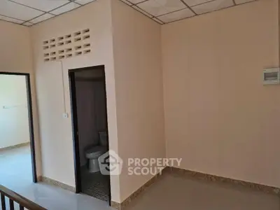Spacious room with attached bathroom in minimalist design, ideal for customization.