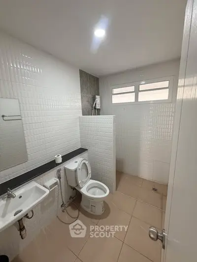 Modern bathroom with white tiles and sleek fixtures in a contemporary home.