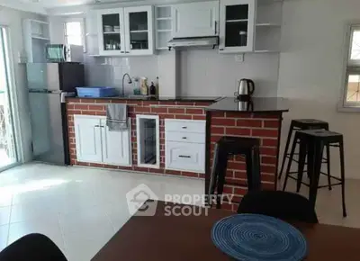 Modern kitchen with brick accents and bar seating in bright open space