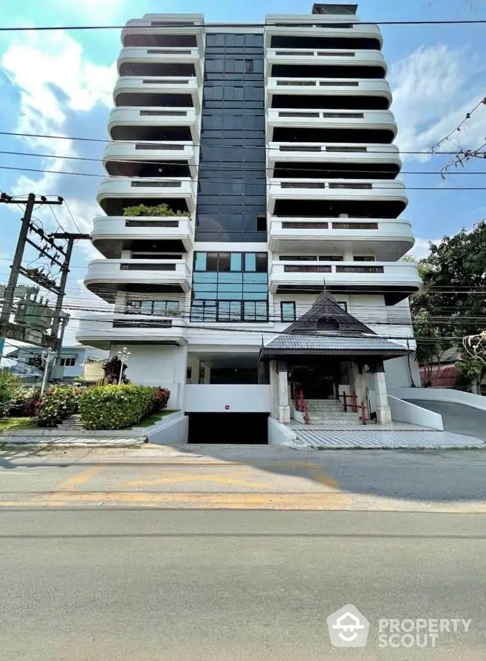 Modern multi-story building with unique architectural design and spacious balconies.