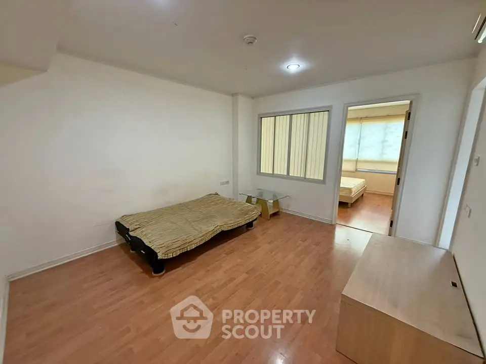 Spacious bedroom with wooden flooring and minimalist decor in modern apartment