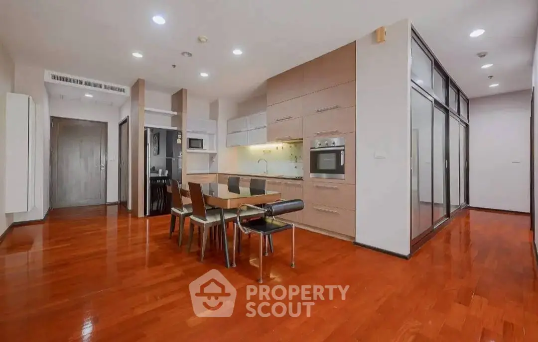 Spacious open-layout kitchen and dining area with modern appliances and wooden flooring.