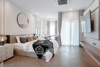 Luxurious modern bedroom with elegant decor and large windows for natural light.