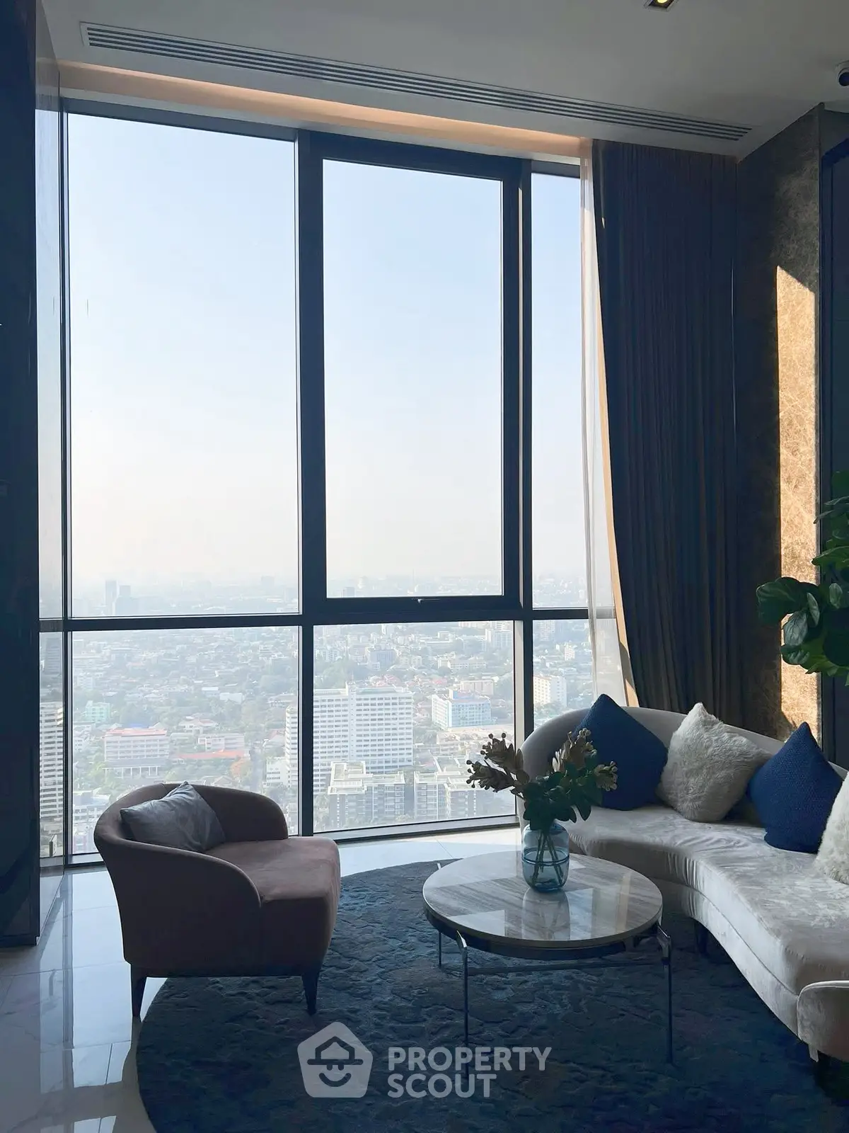 Luxurious high-rise living room with panoramic city view and elegant furnishings.