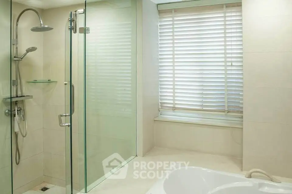 Luxurious bathroom with glass shower and bathtub, perfect for relaxation.