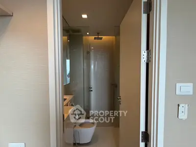 Modern bathroom with sleek fixtures and a glass-enclosed shower in a contemporary apartment.