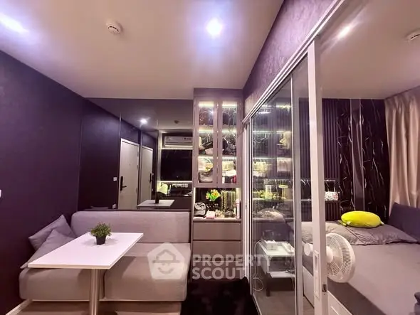 Modern compact living room with glass partition and cozy bedroom setup
