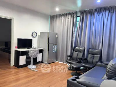 Modern living room with sleek furniture and stainless steel fridge