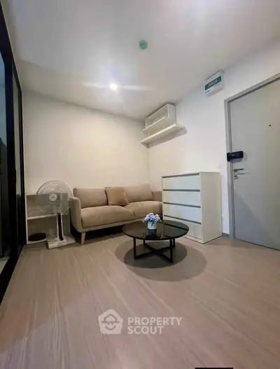 Modern living room with minimalist decor and neutral tones, featuring a cozy sofa and sleek coffee table.