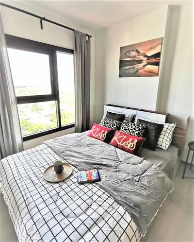 Cozy bedroom with large window and stylish decor in modern apartment
