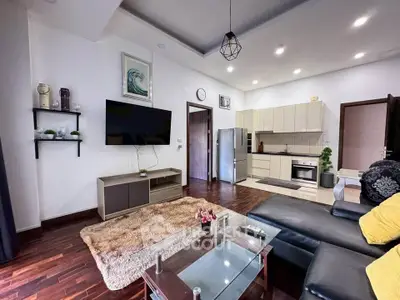 Modern living room with open kitchen, stylish decor, and cozy seating area.