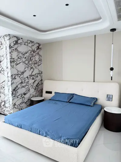 Luxurious bedroom with marble accents and modern design, featuring a plush bed and elegant lighting.