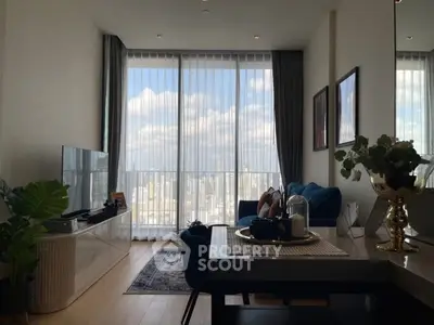 Modern living room with large windows offering stunning city views, stylish furniture, and elegant decor.