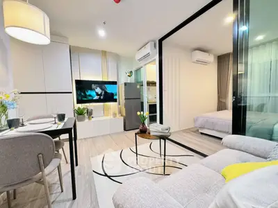 Modern open-plan living room with stylish decor and cozy bedroom view