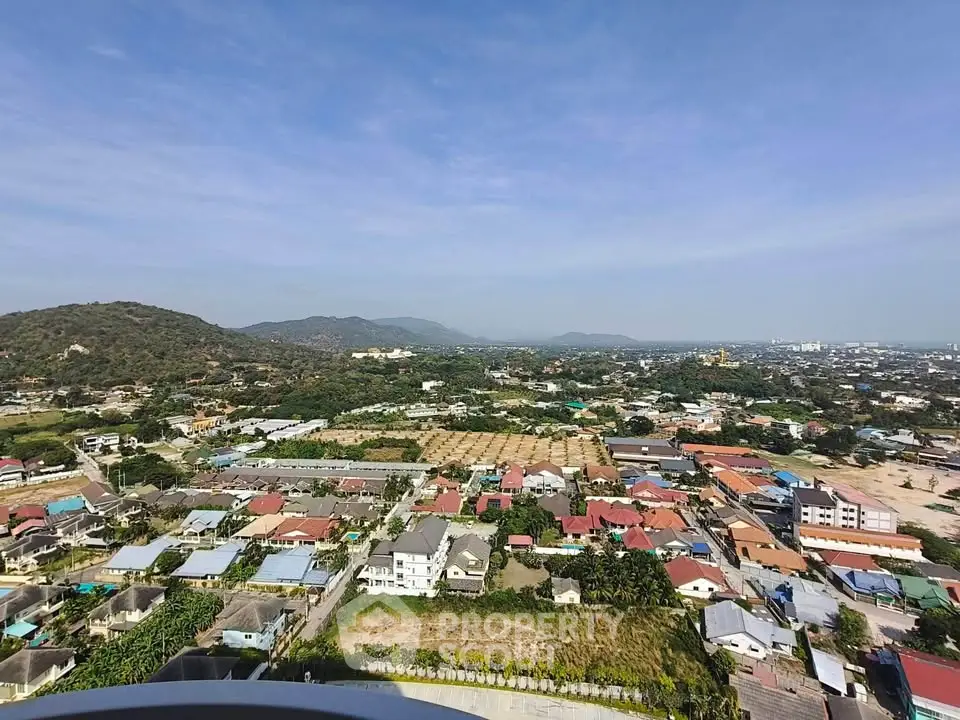 Stunning panoramic view of a vibrant residential area with lush greenery and distant hills.