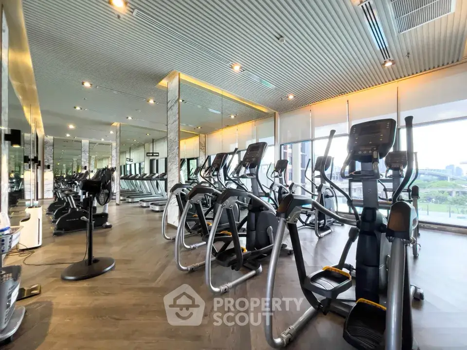 Modern gym with state-of-the-art equipment and panoramic windows in luxury residential building.