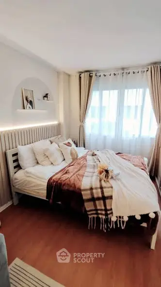 Cozy bedroom with stylish decor and natural light, featuring a comfortable bed and elegant curtains.