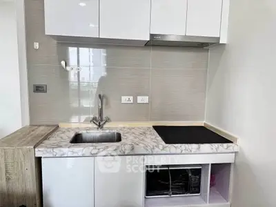 Modern compact kitchen with marble countertop and built-in appliances