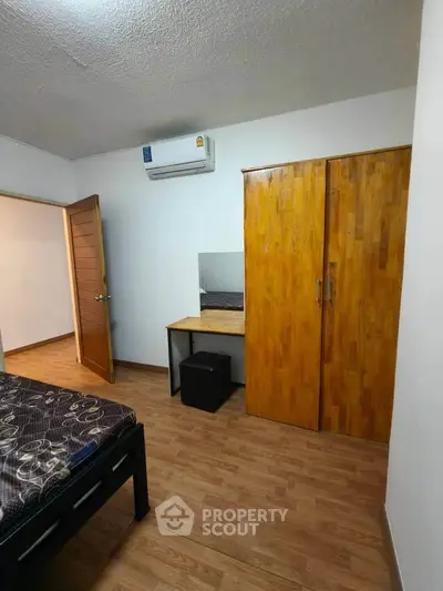 Cozy bedroom with wooden furniture and air conditioning in a modern apartment.