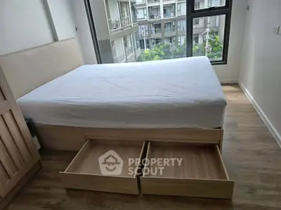 Modern bedroom with storage bed and large window offering city view