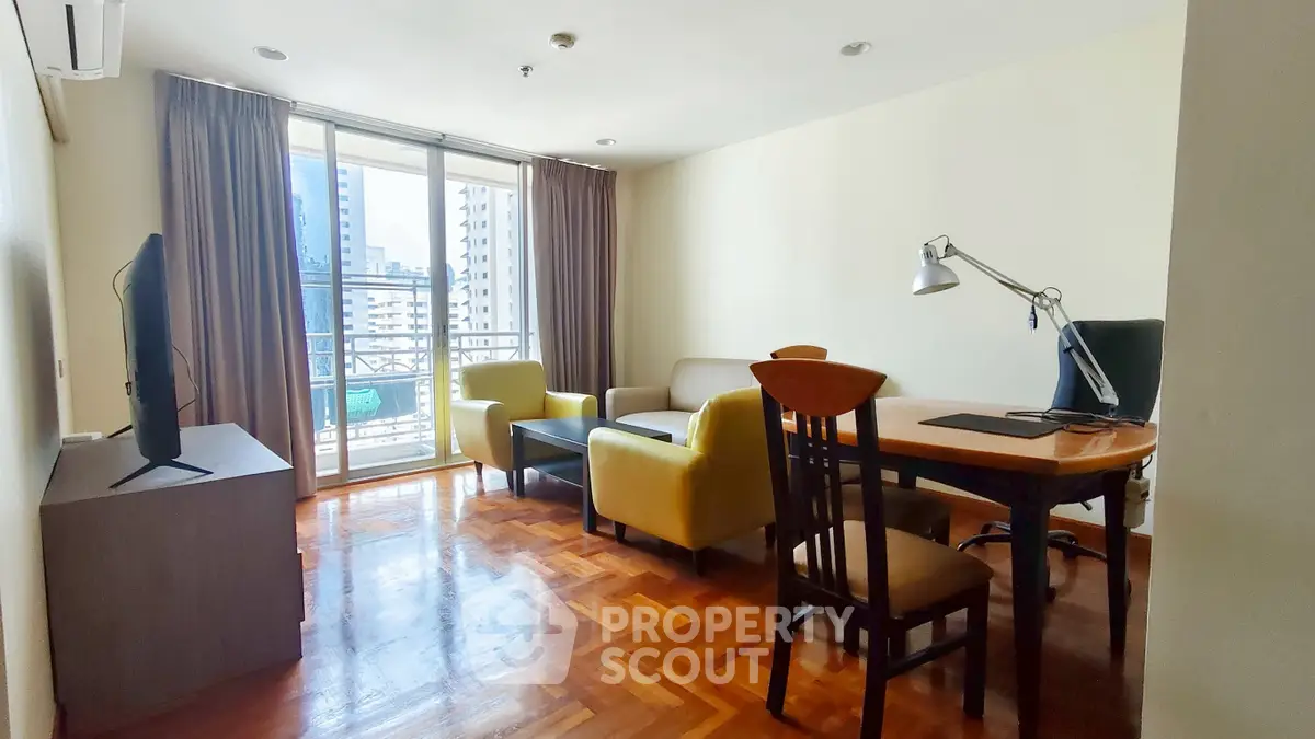 Spacious living room with modern furniture and city view balcony in high-rise apartment.