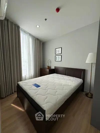 Modern bedroom with sleek design and natural light, featuring a comfortable bed and stylish decor.