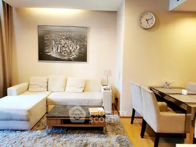 Modern living room with cozy sofa and dining area, featuring stylish decor and warm lighting.