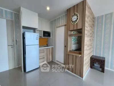 Modern kitchen with sleek appliances and stylish wood paneling in a cozy apartment.